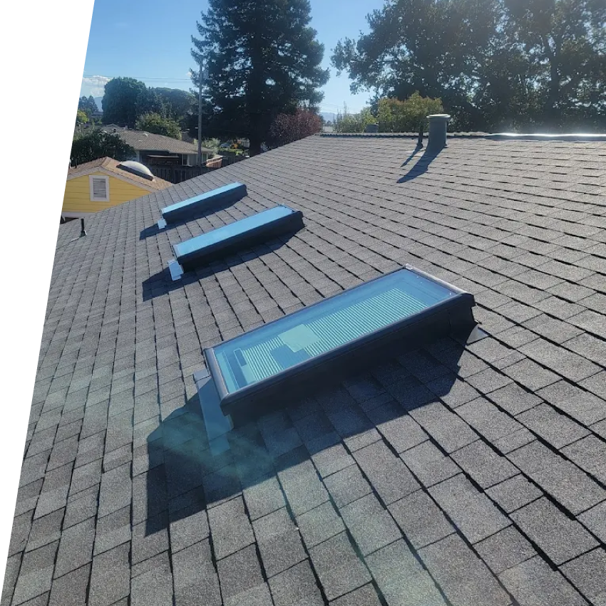 Meticulously installed asphalt shingle roof replacement featuring a clean ridge cap, skylight flashing, and charcoal gray architectural shingles completed by New Concept Roofing Inc.
